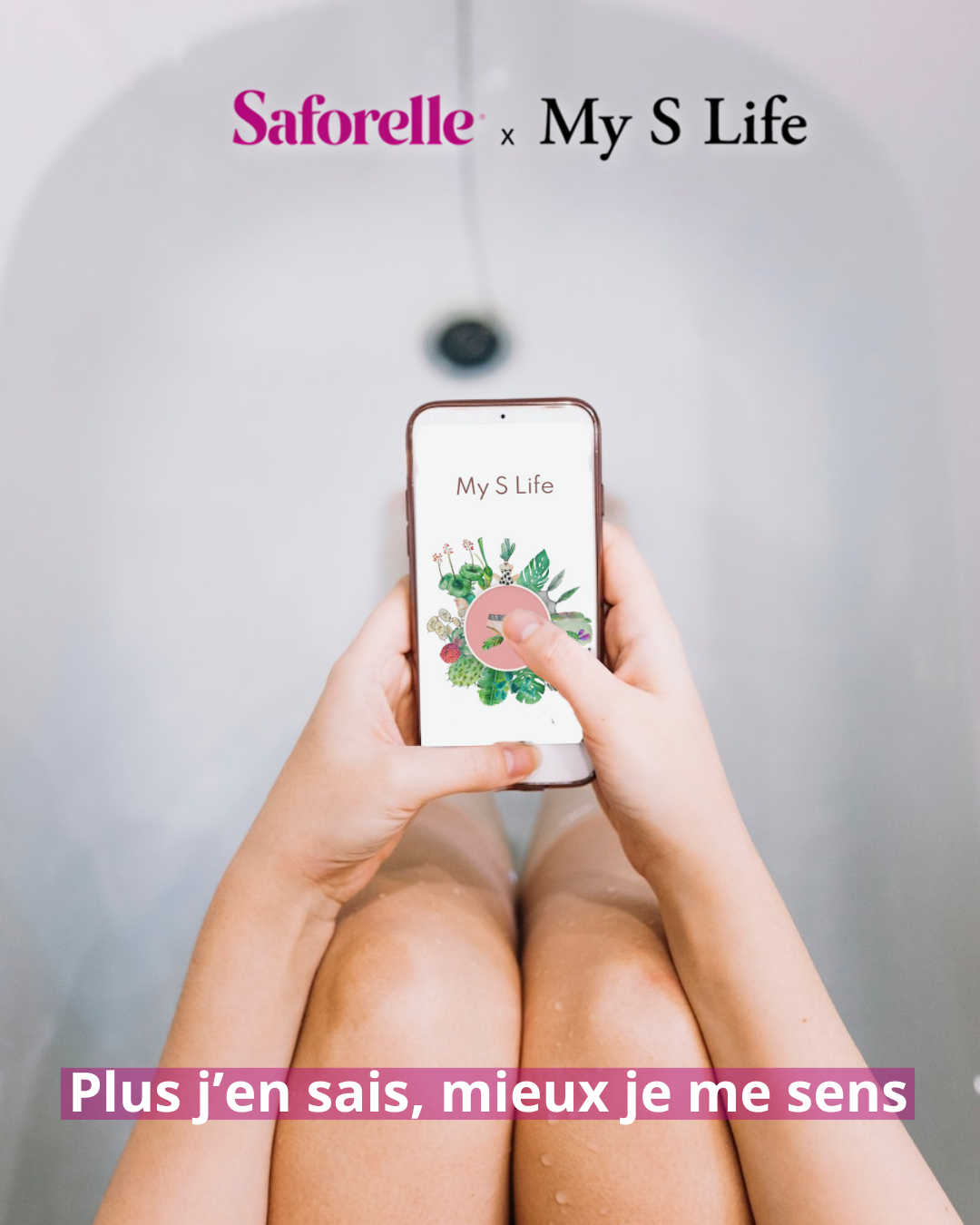 Une femme dans une baignoire tient un smartphone affichant l’application My S Life, partenaire de Saforelle, dédiée à la santé intime. L’écran montre un visuel floral. Le slogan « Plus j’en sais, mieux je me sens » est affiché en bas de l’image en lettres blanches sur fond rose.